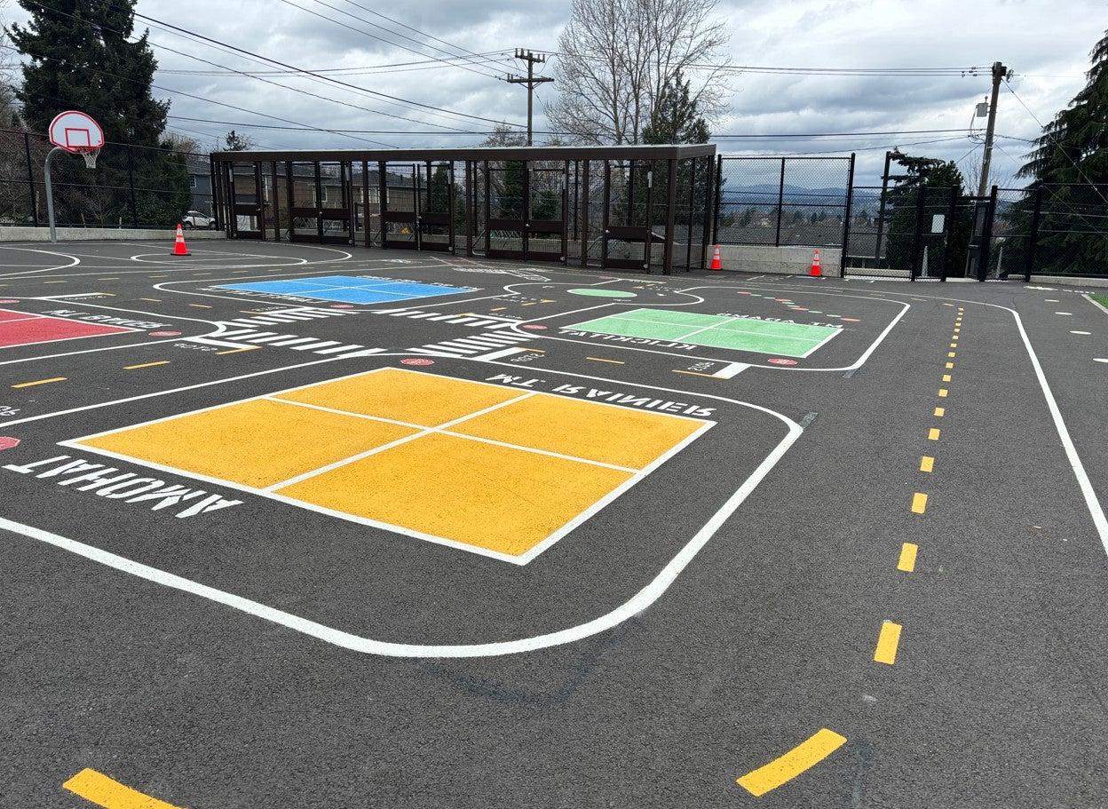 Mini streescape wraps around four square courts on blacktop.